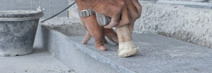 Person verwendet Hammer und Stein